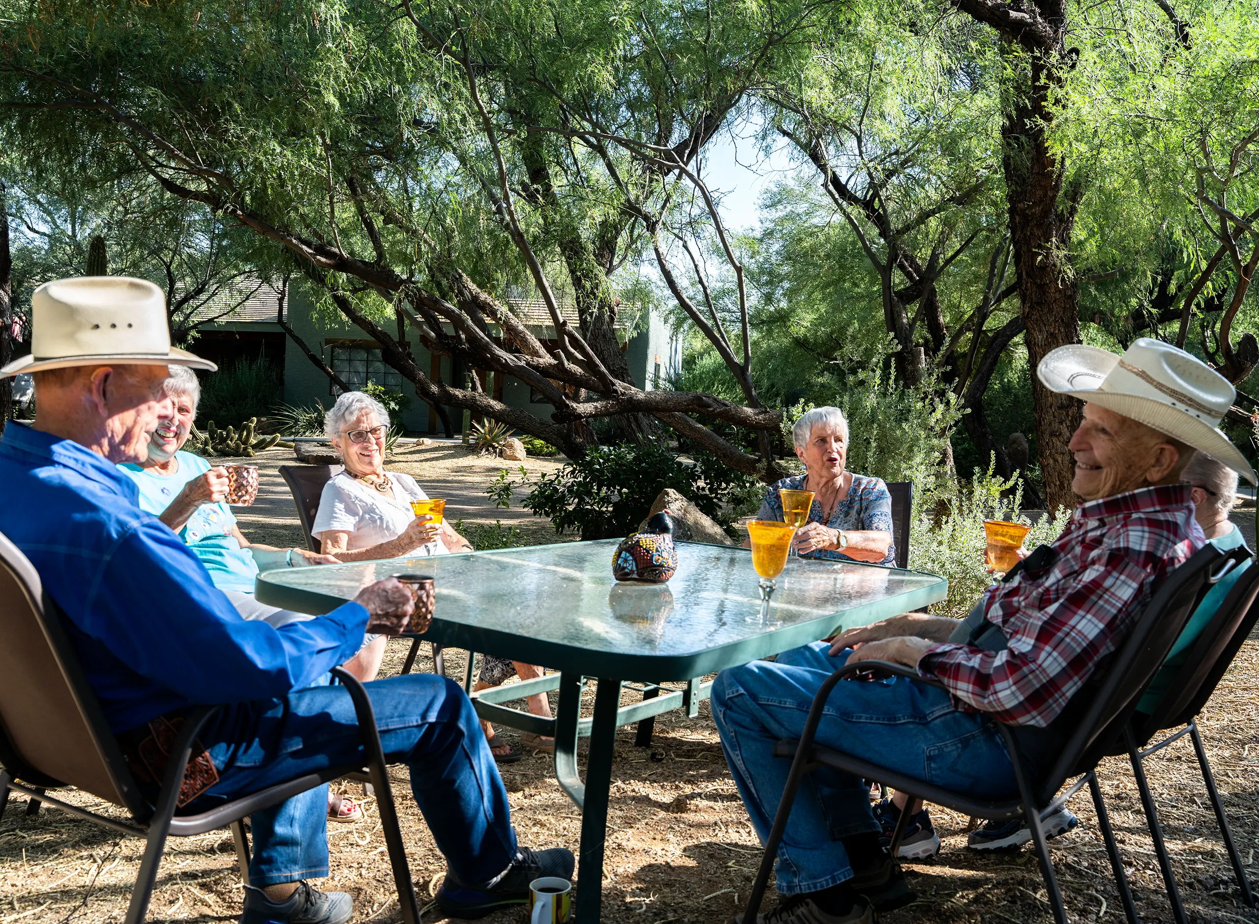 Seniors enjoying ranch style retirement living in Arizona while gathering outdoors at Rustic Ranch Senior Living in Wickenburg